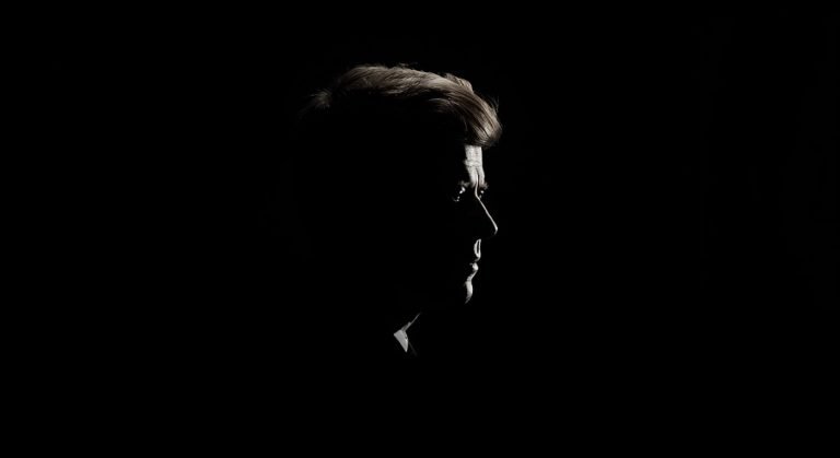 La silueta de perfil de JFK envuelta en un manto de oscuridad