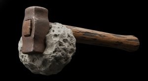 Fotografía detallada del Martillo de Londres, mostrando la fusión entre la cabeza de hierro moderna y la roca caliza del Cretácico.