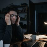 Una persona sentada en un escritorio durante la noche experimenta una intensa sensación psicológica de ser observada.